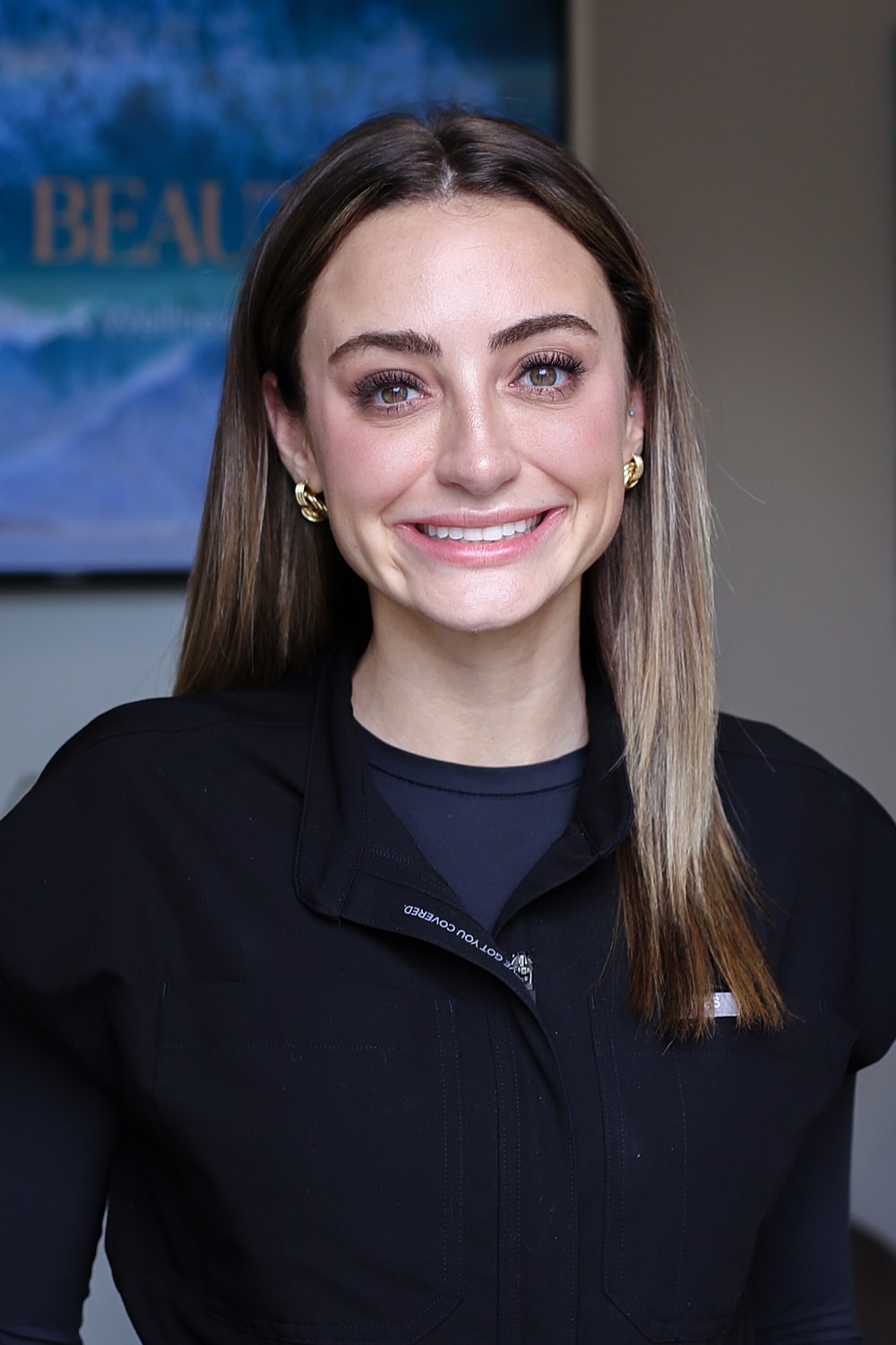 Smiling woman in professional attire, bright background.