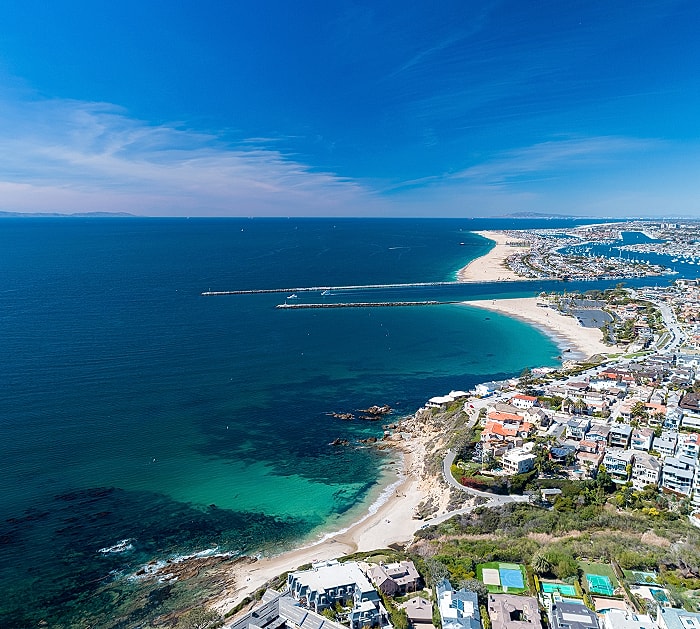 Aerial view of coastal beach and cityscape.