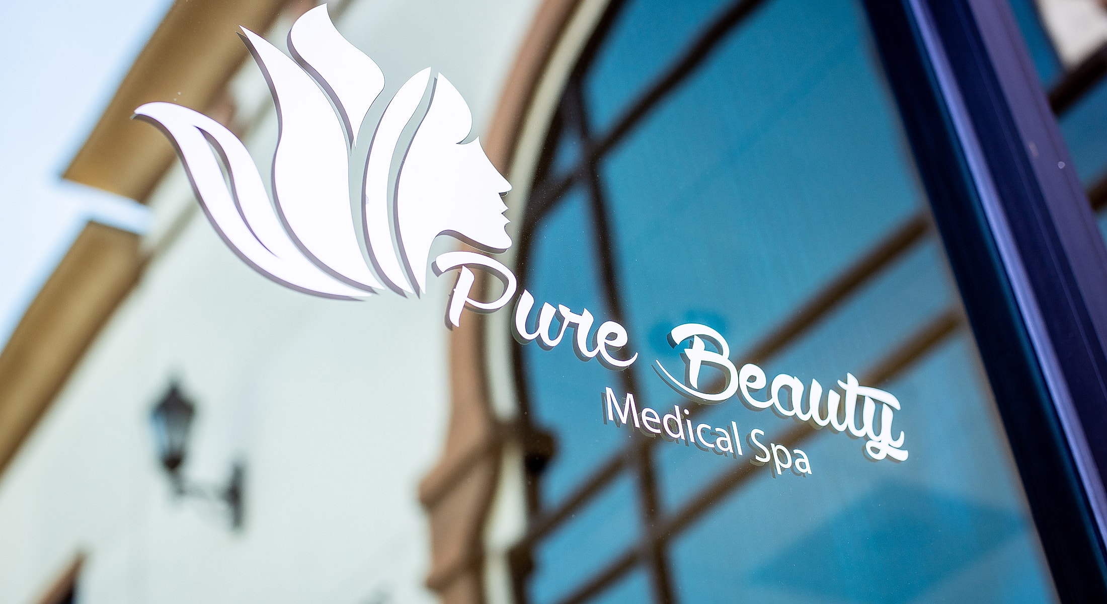 Logo of Pure Beauty Medical Spa on glass.