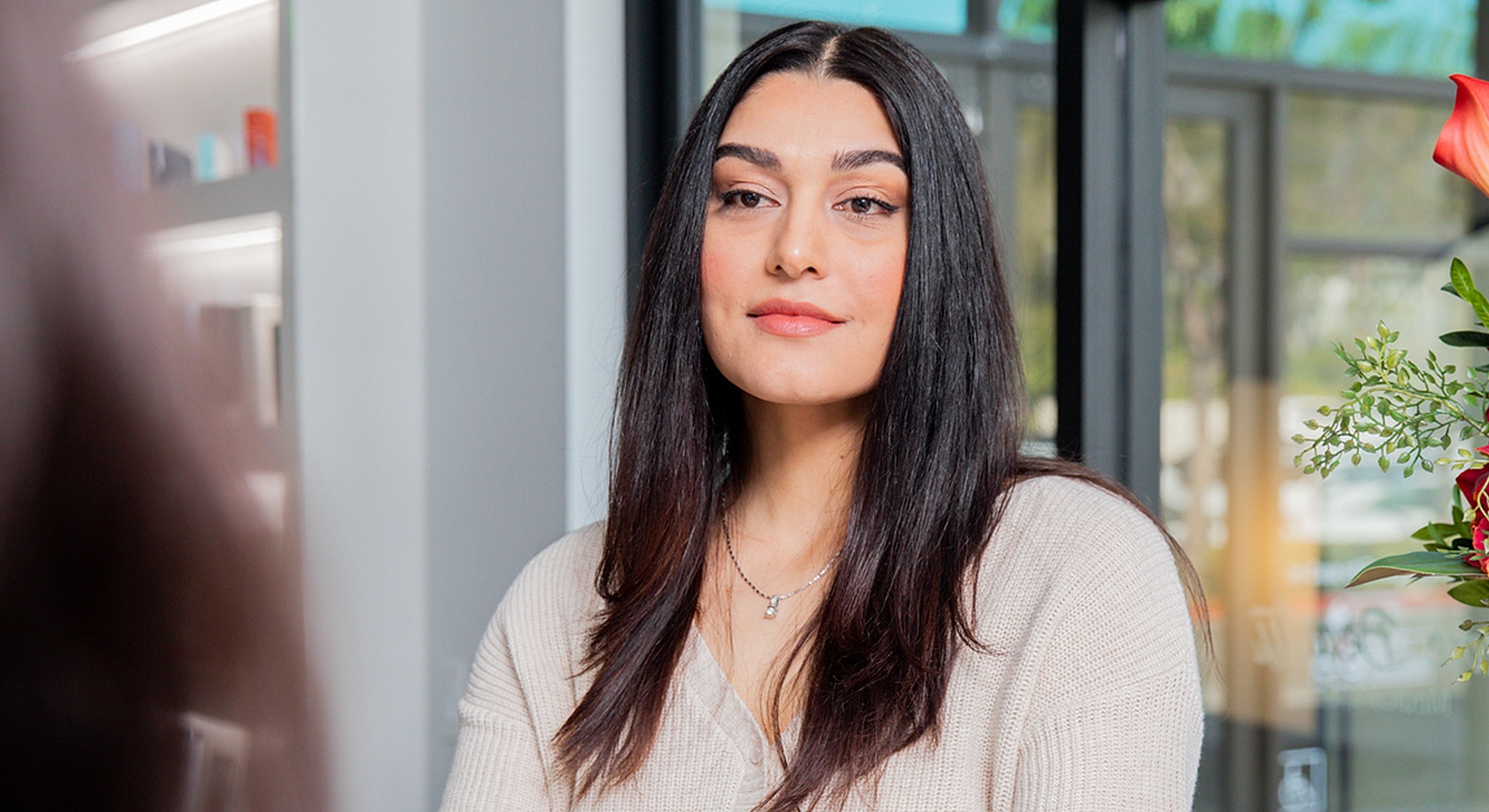 Woman with long hair in bright interior setting.