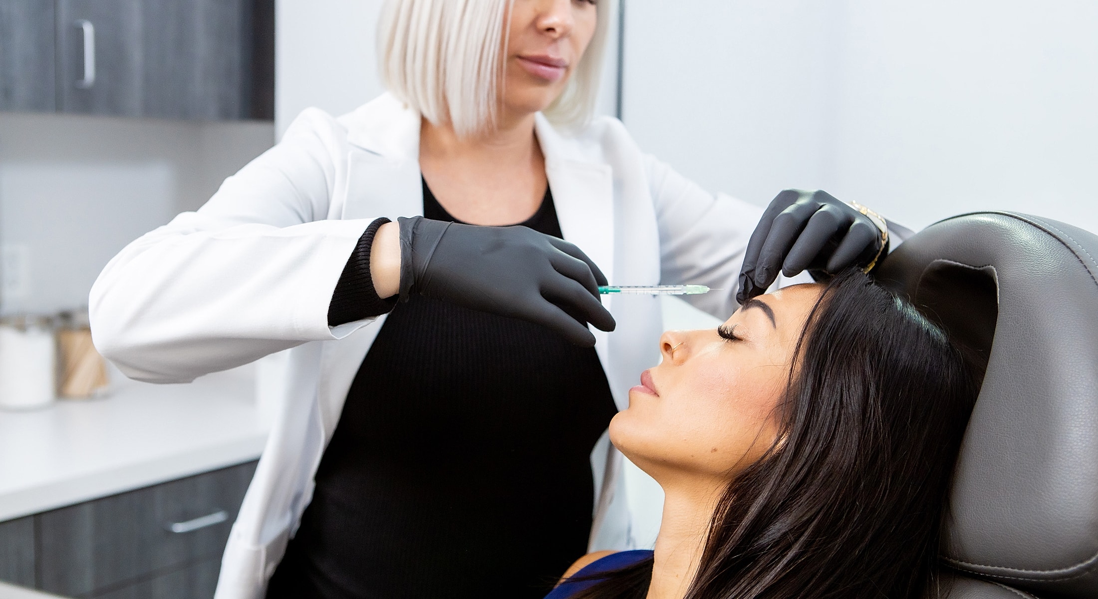 Cosmetic treatment with syringe in clinical setting.