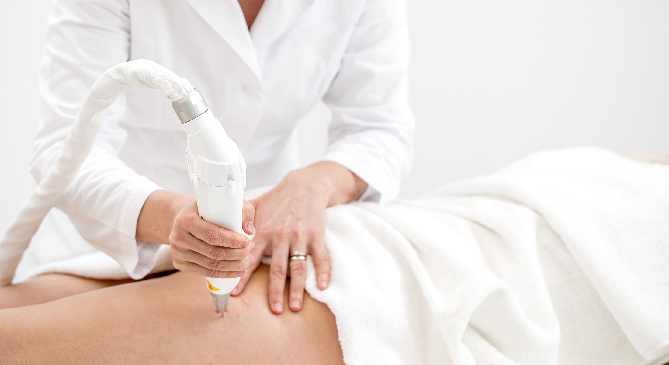 Laser treatment on a patient's thigh by clinician.